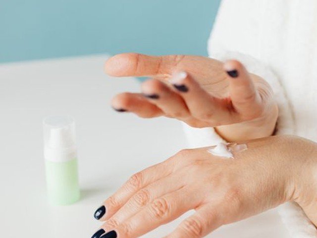 Aplicando crema hidratante como ritual diario de cuidado corporal