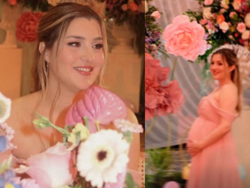 Melenie Carmona con vestido rosa y su pancita en su baby shower, entre flores gigantes